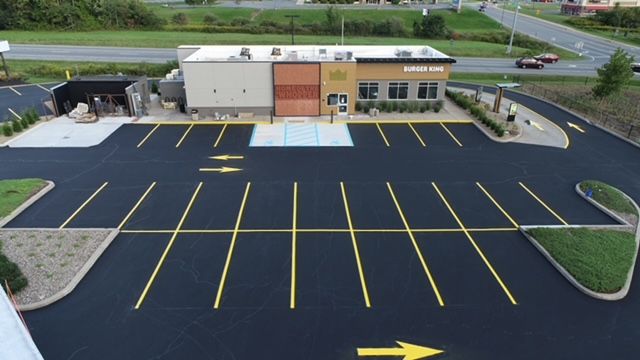 Aerial front view of Burger King with concrete accessible parking spaces, parking aisles and service area