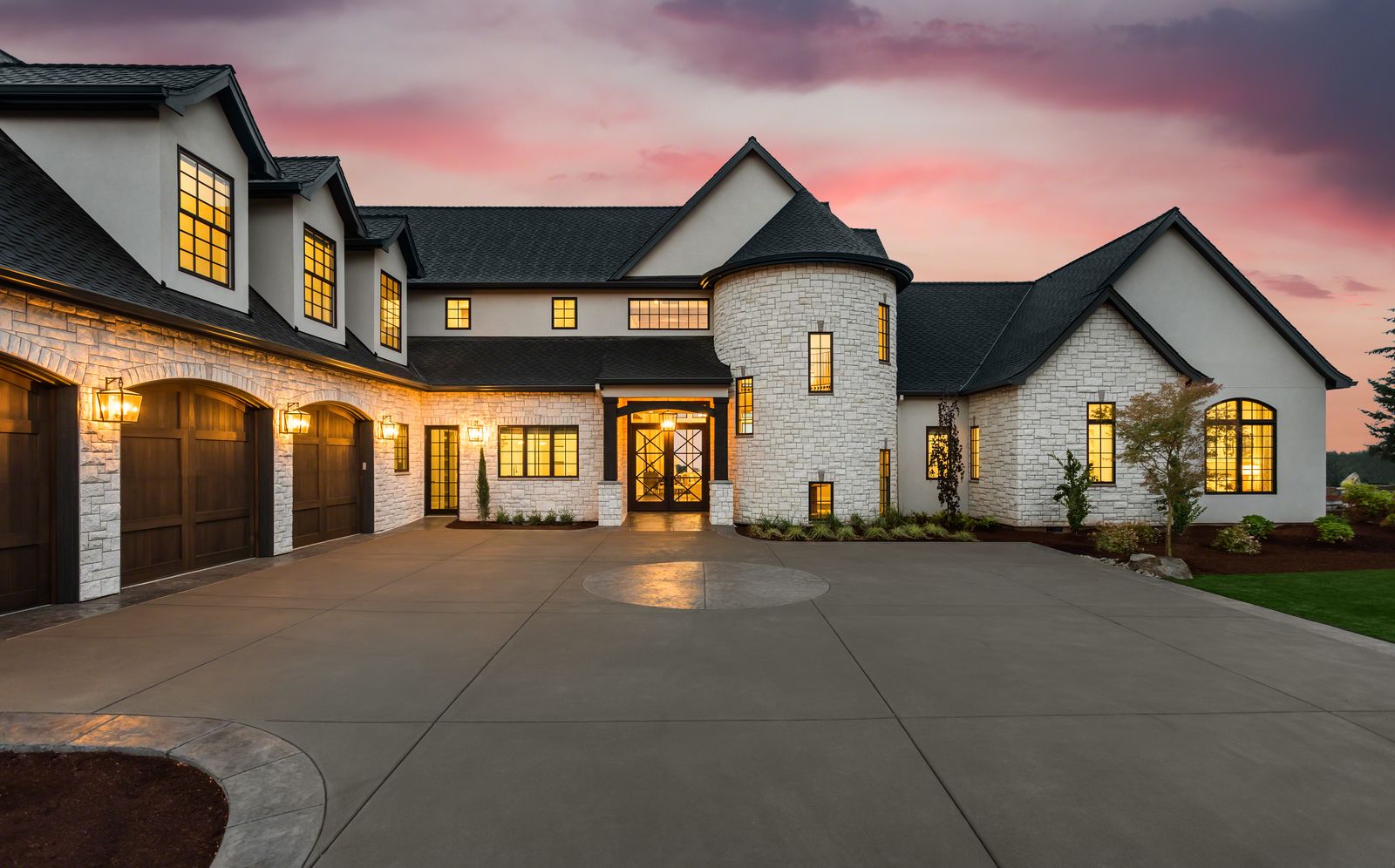 Wide driveway and garage approach in front of a large house