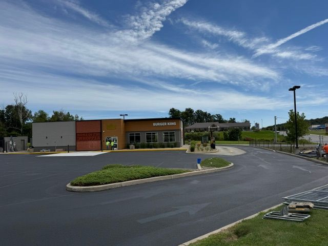 Ground-level view of the Burger King restaurant, concrete curbing and landscaped parking islands