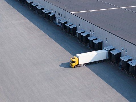 Aerial view of loading bays and delivery trucks beside a distribution building