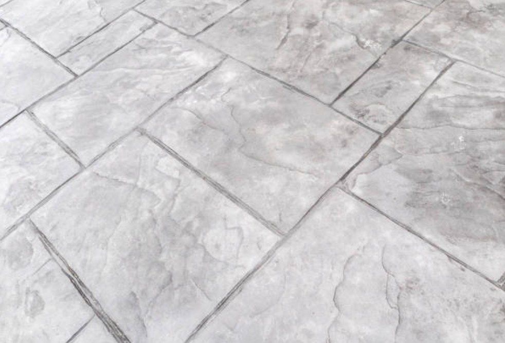Close view of a gray stamped concrete surface with stone-like pattern and joints