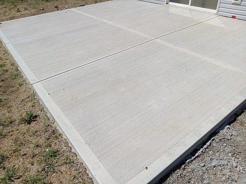 New concrete slab with joints beside a building entrance